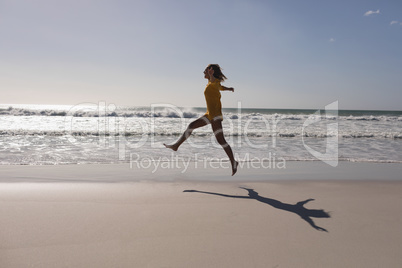 Woman jumping on the beach near seashore