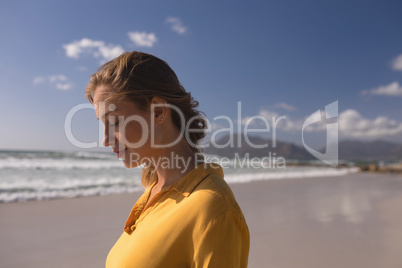 Woman standing with eyes closed on the beach