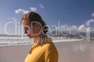 Woman standing with eyes closed on the beach