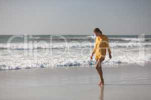 Woman walking on the beach near seashore