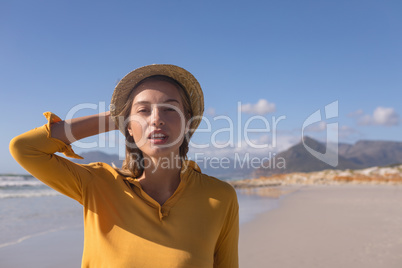 Woman wearing hat standing on the beach