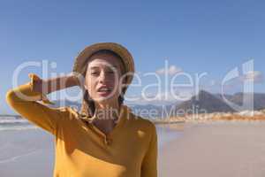Woman wearing hat standing on the beach
