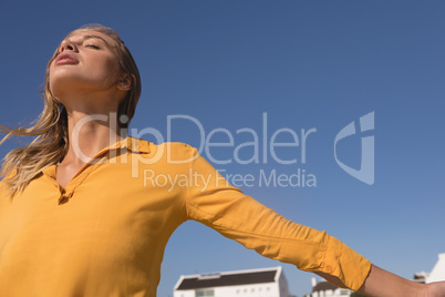 Woman standing with arms outstretched on the beach