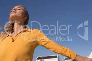 Woman standing with arms outstretched on the beach