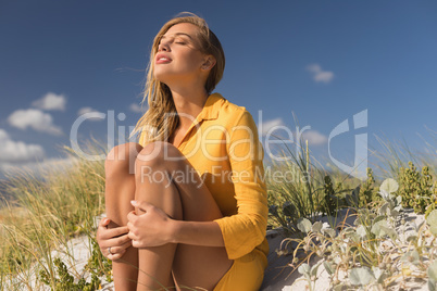 Woman sitting with eyes closed at beach