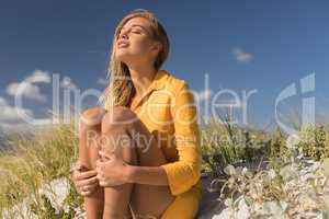 Woman sitting with eyes closed at beach