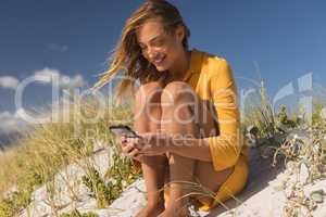 Woman using mobile phone at beach