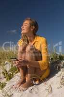 Woman using mobile phone at beach