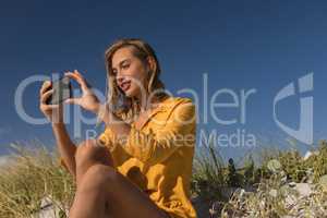 Woman taking selfie with mobile phone at beach