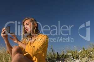 Woman taking selfie with mobile phone at beach