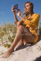 Woman taking selfie with mobile phone at beach