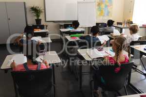 Kids studying in classroom sitting at desks in school
