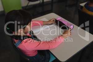 Schoolgirl studying in classroom sitting at desks in school
