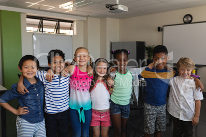 Happy school kids standing in classroom