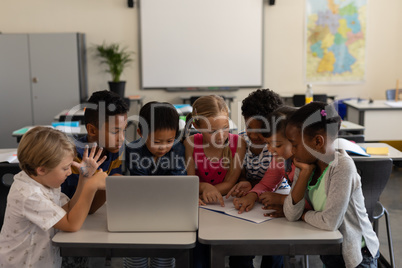 Group of school kids studying together in classroom
