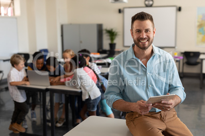 Teacher with digital tablet looking at camera