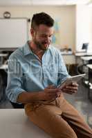 Male teacher using digital tablet in classroom