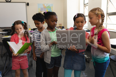 Group of school kids studying together in classroom