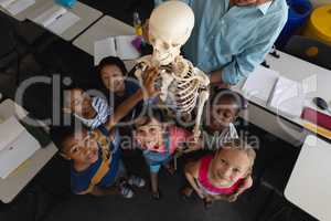 Overhead of schoolkids looking at camera in classroom