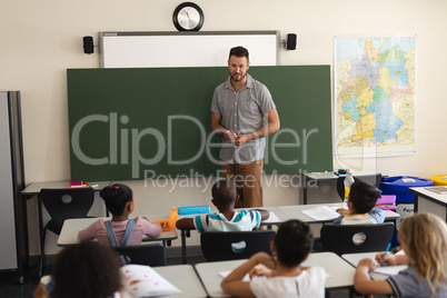 Male teacher teaching in classroom of elementary school