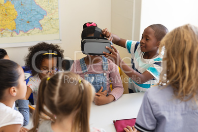 Schoolkids using virtual reality headset in classroom