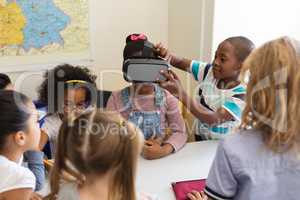 Schoolkids using virtual reality headset in classroom
