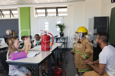 Side view of schoolkids applauding in classroom