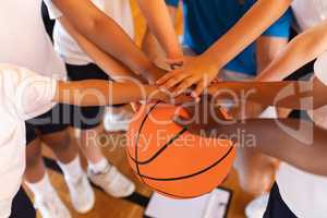 Close-up of Schoolkids forming hand stack on basketball at basketball court
