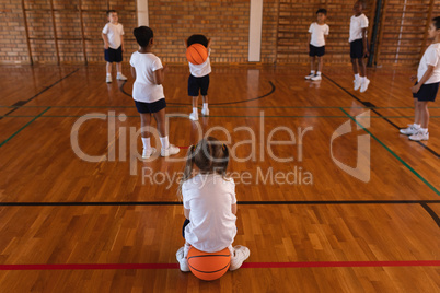 Schoolkids playing basketball at basketball court