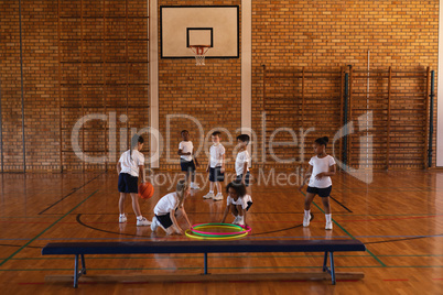 Schoolkids playing basketball at basketball court