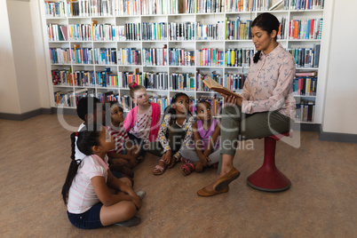 Female teacher reading a story to schoolkids