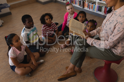 Female teacher reading a story to schoolkids