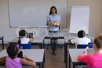 Female teacher explaining anatomy of body parts in classroom