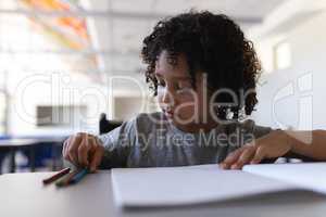 Schoolboy studying at desk in classroom