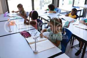 Schoolkids studying at desk in classroom