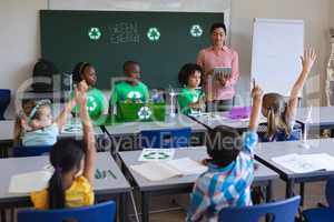 Schoolkids studying about green energy and recycle at desk in classroom