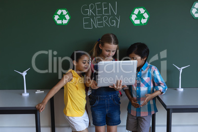 Schoolkids studying on laptop in classroom