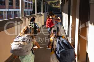 Schoolkids with schoolbags running in hallway