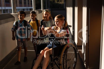Disable schoolgirl using smartphone in hallway