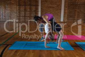 Female yoga teacher teaching yoga to school kids in school