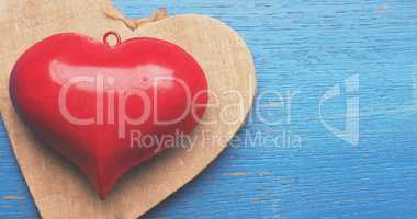 Red metal heart shape on blue wood