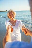Happy Senior Couple Dancing Holding Hands on Sunset Beach
