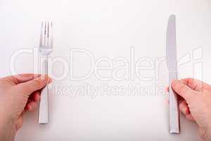 Hands hold knife and fork
