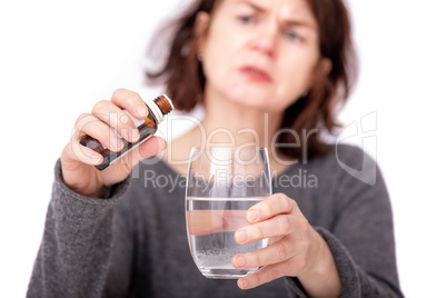 Woman with medicine bottle and water glass