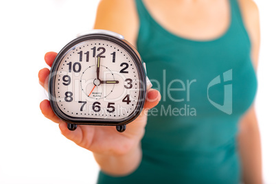Woman is holding alarm clock
