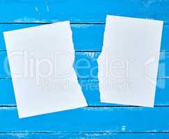 half torn blank white sheet  on a blue wooden background