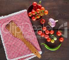 red textile kitchen towel in a cage and fresh cherry tomatoes