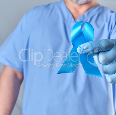 doctor in uniform and latex gloves holding a blue ribbon in his