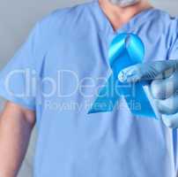 doctor in uniform and latex gloves holding a blue ribbon in his