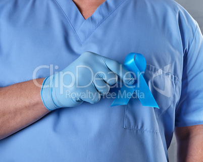 doctor in uniform and latex gloves holding a blue ribbon in his